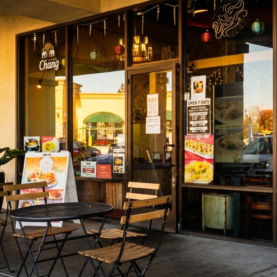 Restaurant Chang's exterior with outdoor seating, potted plants, and menu posters in windows.